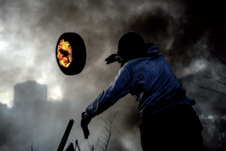 Un manifestant lance un pneu en feu contre la police depuis une barricade à Kiev (Ukraine) Bulent Kilic – 21/02/2014