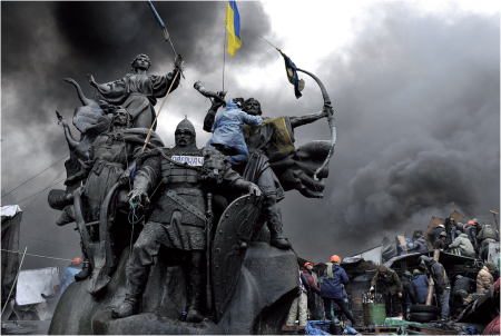 Manifestant juché sur une statue surplombant des barricades à Kiev (Ukraine) Louisa Gouliamaki – 20/02/2014