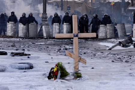Croix dans la neige devant un barrage de policiers lors de manifestations à Kiev (Ukraine) Aris Messinis – 30/01/2014